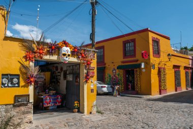 OAXACA, OAXACA, MEXICO-OCTOBER 30 Ekim 2024: Oaxaca, Meksika 'da Ölüler Günü için süslenmiş canlı sarı binalarla sokak manzarası