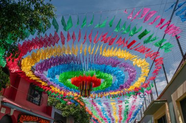 Meksika, Oaxaca 'daki Jalatlaco mahallesinde güneşli bir günde renkli kağıt kesimi dekorasyonu.