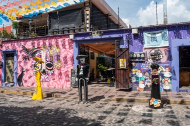 OAXACA, OAXACA, MEXICO-OCTOBER 30 Ekim 2024: Oaxaca, Meksika 'daki Jalatlaco mahallesindeki bir restoranın önünde geleneksel giysiler giymiş iskeletler