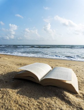 Plaj manzarası üzerine açık bir kitap 