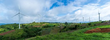 Mavi gökyüzü arka planına sahip tepelerdeki Panorama rüzgar türbinlerinin manzarası. Yenilenebilir enerji kavramı