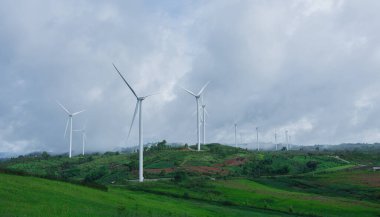 Tepelerin manzarası ve sabah sisli rüzgar türbinleri.
