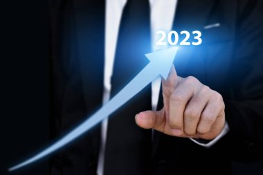 2023 yıllık iş büyüme konsepti. İşadamı ok grafiğini işaret ederek kurumsal gelecek büyütme planı.