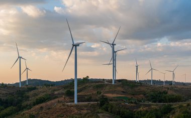Gün batımında mavi gökyüzü arkaplanlı rüzgar türbini alanı. yenilenebilir enerji