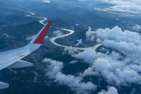 Skrzydło Samolotu Lecącego Nad Szczytami Gór Pokryte Chmurami Widok Wzgórza — Zdjęcie stockowe