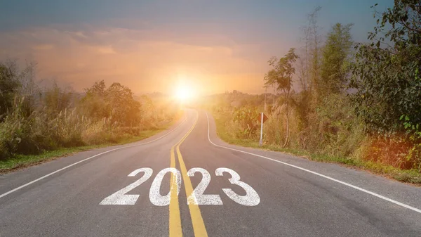 stock image New year 2023 forward concept. Word 2023 written on the asphalt road at sunset sky. Concept of planning, challenge and goal.