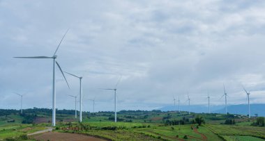 Tarım alanlarında bulutlu gökyüzü olan panorama rüzgar türbinlerinin manzarası. Yenilenebilir dostane enerji kavramı