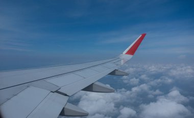 Beyaz bulutlarla gökyüzünde uçan uçak kanadı. Uçak penceresinden bak. Uçma ve seyahat kavramı.