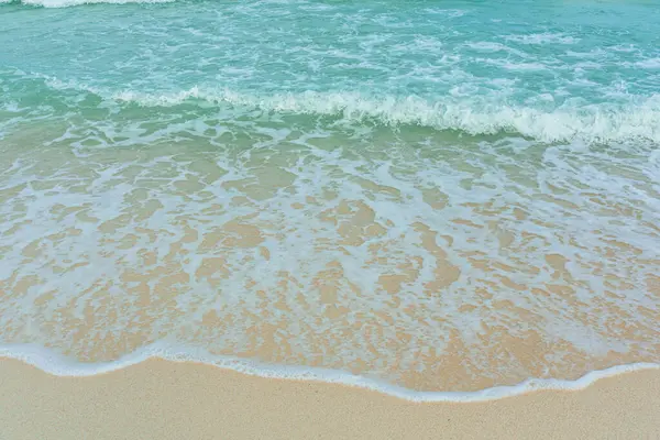 Kumlu sahilde yumuşak bir mavi okyanus dalgası. Adaya yaz tatili. berrak gök mavisi arka plan.