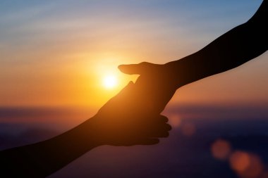 Gün batımında birbirimize yardım etme, umut ve destek olma silueti..