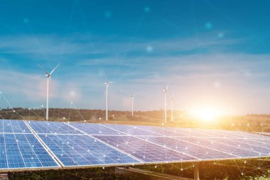 Güneş panelleri ve rüzgar türbinleri günbatımı arka planına sahip akıllı şebekeye bağlı. Fotovoltaik, alternatif elektrik kaynağı. sürdürülebilir kaynaklar kavramı.