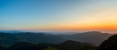 Dağ ormanının doğal manzarası, günbatımında gökyüzü arka planında. Doğa manzarası.