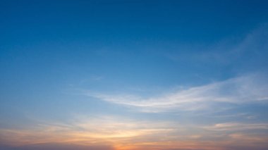 Gün doğumunda ya da günbatımında yumuşak bulutlu mavi gökyüzü. Doğa arkaplanı