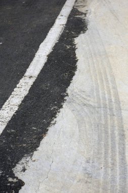 Bir sürü siyah ve gri çizgili beyaz asfalt yol.