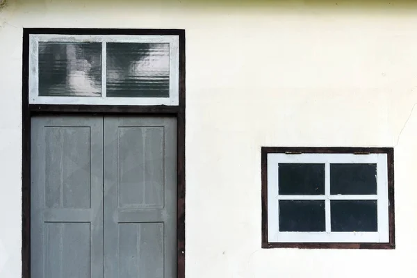 墙上有木门的白色窗户 — 图库照片