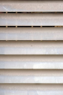 Büyük bir penceresi olan beyaz ahşap bir duvarın ve ahşap bir duvarın gölgesi olan bir pencerenin yakınında. Tahta kalasların dokusu. 