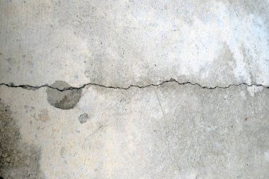 Çatlakları ve çizikleri olan beton bir duvarın dokusu arka plan olarak kullanılabilir.