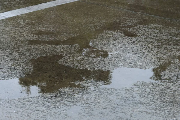 rain drops and wet puddle on the road