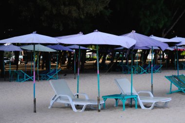 Kumsalda boş bir plaj sandalyesi.