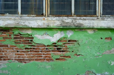 Yeşil alçılı eski tuğla duvar.