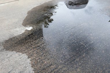 ıslak asfalt yüzeyi suyun yansıması ile.