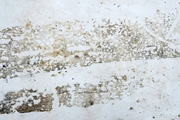 Çizikler ve soyulmuş boyalarla dolu eski bir duvar..