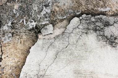 Çizikler ve soyulmuş boyalarla dolu eski bir duvar.