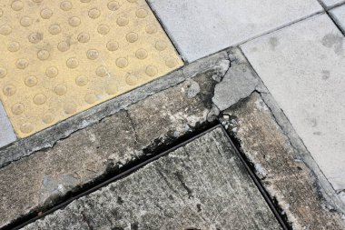 Kaldırımda sarı ve beyaz fayanslar var..