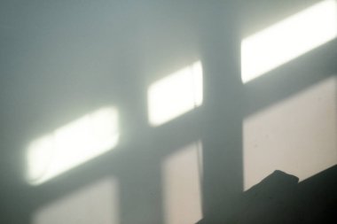 Beyaz bir duvardaki pencere gölgesi.