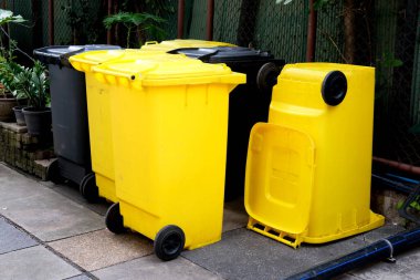 Halk parkında sarı çöp kutusu