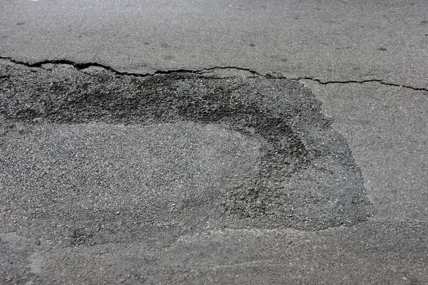 arkaplan dokusu olarak çizikleri ve çatlakları olan asfalt