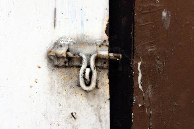 Eski kapıda zincirli paslı kilit.