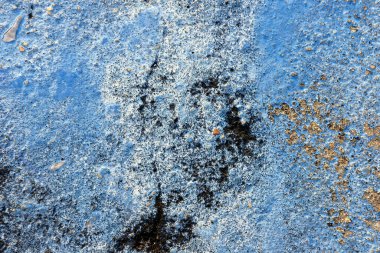 Eski paslı metal duvarda çizikler ve çatlaklar var.