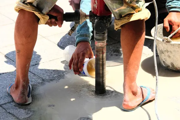 Duvarı fırçayla boyayan işçiler