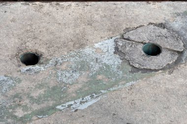 Ortasında çatlaklar olan paslı metal bir delik.