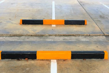 Beton duvarda turuncu ve siyah park işaretleri