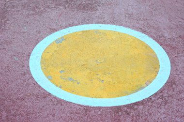 Beton zeminde sarı ve kırmızı daire