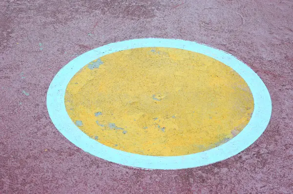 Beton zeminde sarı ve kırmızı daire