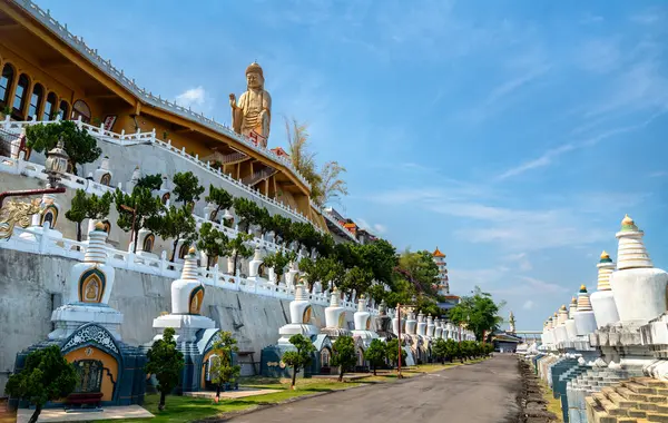 Kaohsiung, Tayvan 'daki Fo Guang Shan Manastırı' nın heykeli teras, bonsai ağaçları ve geleneksel Çin mimarisi ile süslenmiş altın Buda heykeli. Açık gökyüzü ve simetrik hizalama