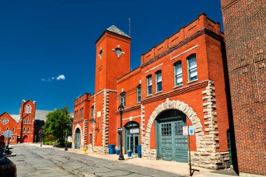 Pittsfield, Massachusetts, ABD 'de kırmızı tuğlalı bir itfaiye binası. Kemerli taş kapıları ve mavi gökyüzünün altında merkezi bir kulesi var.