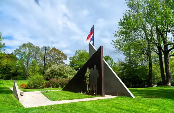 Hallowell, Maine - 25 Mayıs 2025: Vietnam Savaşı gazilerinin anısına ABD 'nin Augusta kentindeki sessiz bir yeşil parka yerleştirilmiş asker siluetleri ve Amerikan bayraklarıyla modern üçgen anıt