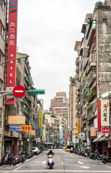Taipei, Tayvan - 12 Nisan 2025: Wanhua Bölgesi 'nde bulutlu bir gündüz manzarası, dikey Çin mağaza işaretleri, kırmızı fener çelenkleri ve yıpranmış apartman cepheleriyle dolu dar bir şehir sokağına bakıyor.
