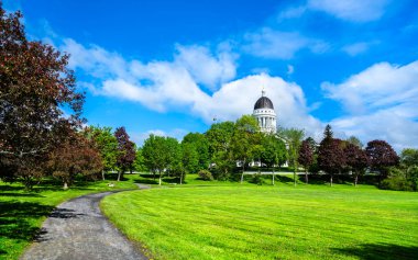 Birleşik Devletler 'in Augusta şehrinde, Maine State House kubbesi Capitol Park' ın üzerinde, parlak mavi gökyüzünün altında kıvrımlı bir çakıl yolunun estiği yerde..