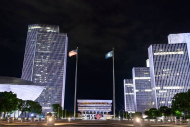 Albany, New York - 25 Mayıs 2025: Empire State Plaza karanlık çöktükten sonra parlıyor: Corning Tower, ajans blokları ve yumurta çerçevesi Kültürel Eğitim Merkezi, aydınlatılmış bir New York tabelasıyla sivil gururu yansıtan bir tabela