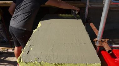 İşçinin eline malayla bak, yalıtım için sarı mineral yününe yapıştırıcı sür bina, inşaat alanı.... 
