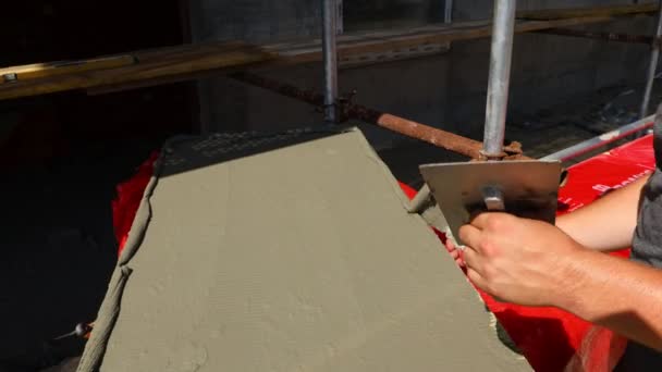 工人手部用汤匙观察 用胶水涂敷黄色矿棉作为建筑物 建筑工地的绝缘材料 — 图库视频影像