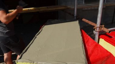İşçinin eline malayla bak, yalıtım için sarı mineral yününe yapıştırıcı sür bina, inşaat alanı.... 