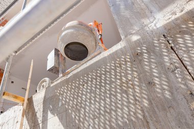 İnşaat halindeki binanın balkonuna konan çimento karıştırıcı makinesinin böğürtüsünden çekilen iskelenin yanına da bina iskelesi monte edilmiş..