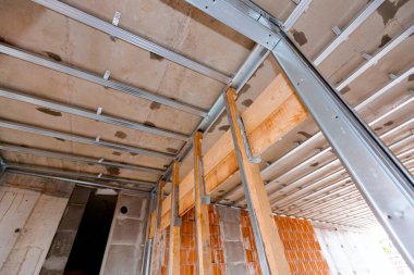 Bölme duvarı ve tavan, inşaat halindeki konut binası için metal ve ahşap dikey profil sütunları çerçevesine bak.