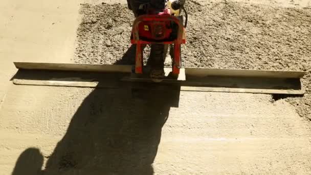 Bauarbeiter Nivelliert Frischen Beton Mit Motorwerkzeug Vibrationsmetalllatte Zement Nach Dem — Stockvideo